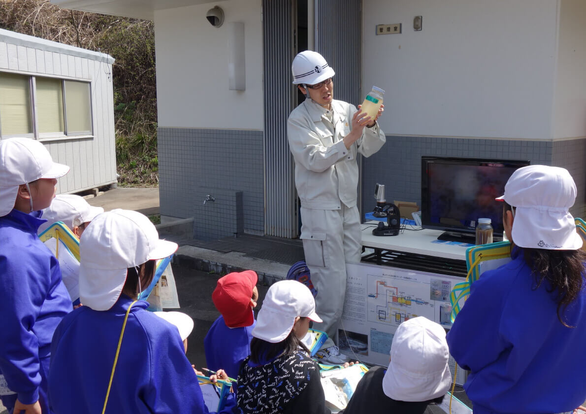 下水道設備を見学する小学生